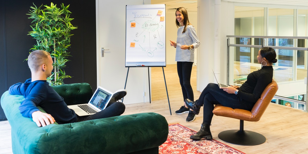two-person-listening-to-woman-standing-beside-poster-1647919